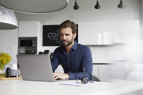 Man working on laptop while sitting at cafeteria stock photo