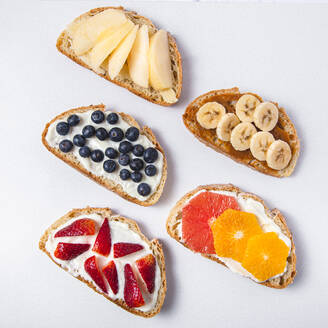 Studioaufnahme von fünf Brotscheiben mit frischen Früchten - FLMF00294