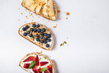 Studio shot of three slices of bread with fresh fruits - FLMF00295