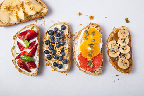 Studioaufnahme von fünf Brotscheiben mit frischen Früchten - FLMF00296