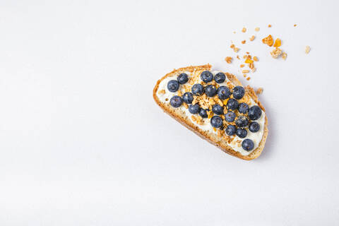 Studioaufnahme einer Scheibe Brot mit Blaubeeren und Müsli, lizenzfreies Stockfoto