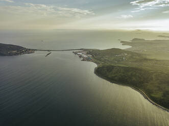 Russia, Primorsky Krai, Zarubino, Aerial view of coastline of Sea of Japan at sunset - KNTF05322