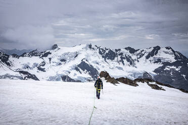 Älterer Mann beim Wandern in schneebedeckter Landschaft gegen den Himmel, Stilfserjoch-Nationalpark, Italien - MCVF00602