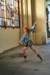 Young alternative redhead girl dancing in roller skates - CAVF89129