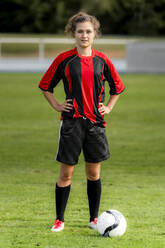 Female player with soccer ball standing on field - STSF02609