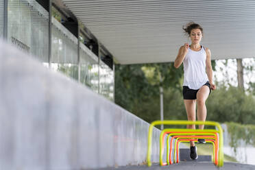 Seriöse Sportlerin läuft über kleine Hürden - STSF02617
