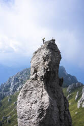 Männlicher Wanderer steht auf dem Gipfel eines Berges gegen den Himmel, Europäische Alpen, Lecco, Italien - MCVF00611