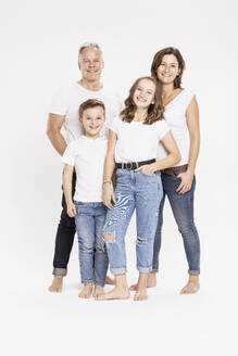 Happy family posing while standing against white background - SDAHF00972