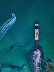 Luftaufnahme eines kleinen Piers und eines Jetboots im türkisfarbenen Wasser - KNTF05374