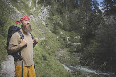 Bärtiger Mann mit Kopftuch im Wald stehend, Otschergraben, Österreich - HMEF01071