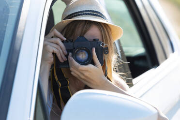 junge Frau hält Kamera, während sie im Auto sitzt - JSRF01124