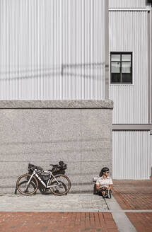 Fahrradtourist macht Pause auf dem Bürgersteig in Portland, Maine - CAVF89242