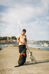 Man with dogs at beach against cloudy sky - DCRF00870