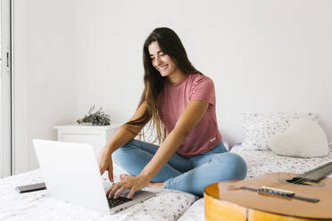 Junge Frau, die zu Hause sitzend am Laptop lernt - XLGF00539