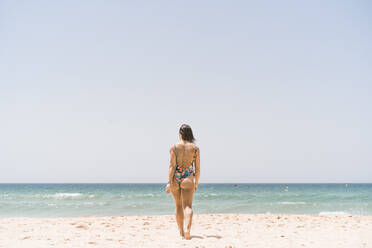 Frau im Bodysuit beim Spaziergang am Strand von Valdevaqueros in Tarifa, Spanien - DAMF00461