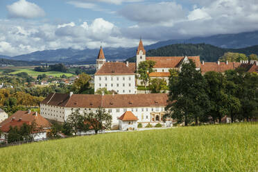 Österreich, Kärnten, Sankt Paul im Lavanttal, Frühlingswiese mit Stift Sankt Pauls im Hintergrund - AIF00701