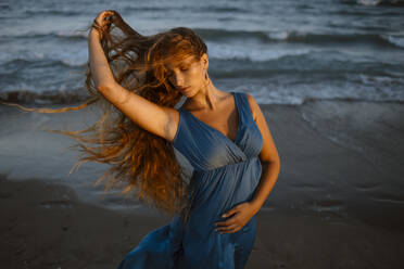 Frau mit Hand tanzen am Strand bei Sonnenuntergang - GMLF00623