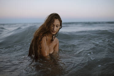 Junge Frau genießt im Wasser am Strand - GMLF00633