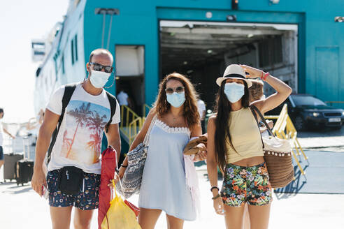 Freunde mit Masken stehen vor einem Kreuzfahrtschiff im Hafen - EGAF00753