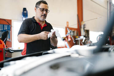 Männlicher Mechaniker repariert Auto in einer Autowerkstatt - EGAF00773