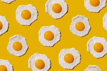 Pattern of fried eggs against yellow background - GEMF04148