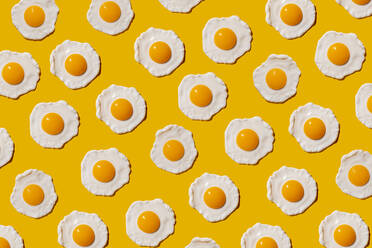 Pattern of fried eggs against yellow background - GEMF04149
