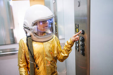 Junge im Raumanzug drückt Knöpfe im Aufzug - JCMF01473