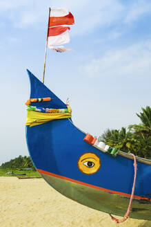 Buntes Fischerboot mit indischer Flagge und goldenen Augenmotiven am Marari Beach, Mararikulam, Alappuzha (Alleppey), Kerala, Indien, Asien - RHPLF17512