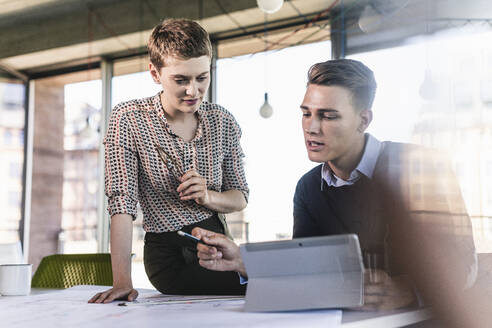 Male and female professionals planning at desk in office - UUF21510