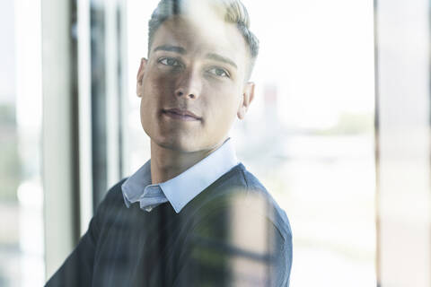 Close-up of thoughtful male professional seen through window in office stock photo