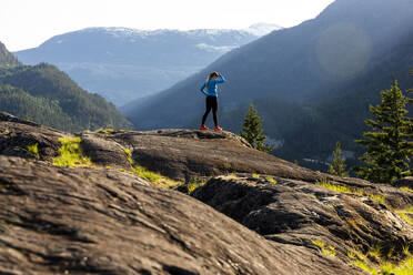 Eine starke Sportlerin macht eine Pause vom Laufen während eines Fitnesstrainings in der Natur bei Sonnenuntergang. - CAVF89291