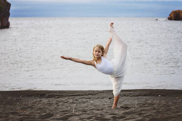 Junges blondes Mädchen tanzt am Strand - CAVF89310