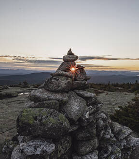Steinhaufen vor der untergehenden Sonne auf dem Gipfel des Baldpate Mountain, Maine - CAVF89397