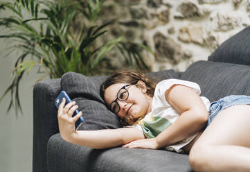 Little girl taking selfie on smart phone at home - DGOF01439