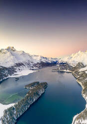 Aerial view by drone of snow capped Piz Da La Margna and Lake Sils at sunrise, Engadine, canton of Graubunden, Switzerland, Europe - RHPLF17640