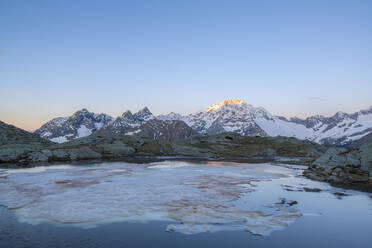 Sonnenaufgang über dem verschneiten Gipfel des Monte Disgrazia, Alpe Fora, Valmalenco, Provinz Sondrio, Valtellina, Lombardei, Italien, Europa - RHPLF17652