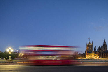 Ein roter Londoner Bus fährt unscharf über die Westminster Bridge, London, England, Vereinigtes Königreich, Europa - RHPLF17737