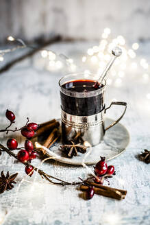Weihnachtsbeleuchtung, Hagebutten und eine Tasse Glühwein mit Zimtstangen und Sternanis - SBDF04365