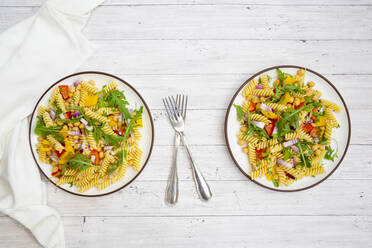 Zwei Teller mit vegetarischem Nudelsalat mit Kichererbsen, Paprika, Rucola, Zwiebel, Petersilie und Basilikum - LVF09005