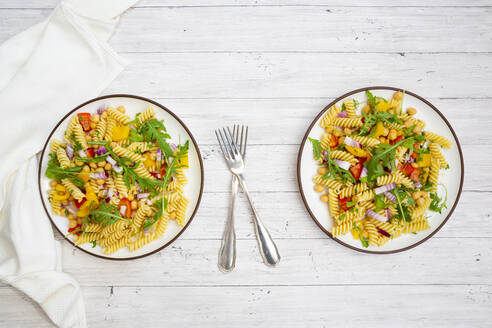 Zwei Teller mit vegetarischem Nudelsalat mit Kichererbsen, Paprika, Rucola, Zwiebel, Petersilie und Basilikum - LVF09005