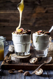 Two glasses of Greek yogurt with honey, figs and walnuts - SBDF04367