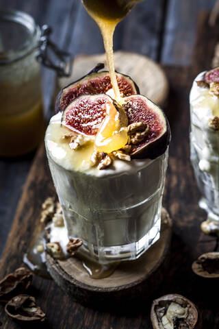 Glass of Greek yogurt with honey, figs and walnuts stock photo