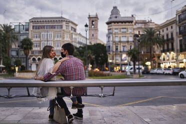 Ehepaar auf einer Bank in der Stadt sitzend - SASF00124
