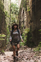 Junge Frau erkundet einen Canyon mit Action-Kamera und GPS. - CAVF89444