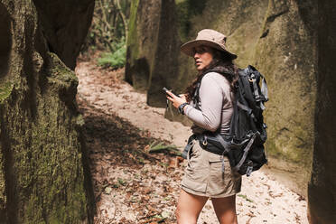 Frau mit GPS und Rucksack schaut zurück. - CAVF89447