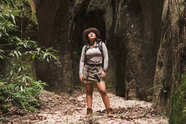 Woman looking up in a canyon with sunlight in front. - CAVF89448