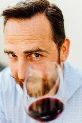 Close up portrait of man with moustache holding glass of red wine - CAVF89465