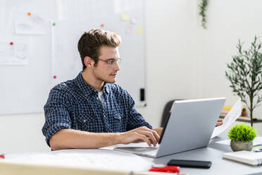 Architekt arbeitet am Laptop, während er am Tisch im Büro sitzt - GIOF08863