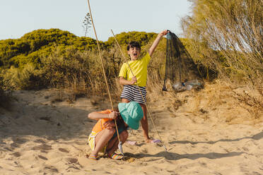 Cheerful friends cleaning beach - ERRF04460