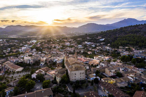 Spain, Mallorca, Calvia, Helicopter view of Parroquia Sant Joan Baptista church and surrounding buildings at sunset - AMF08494